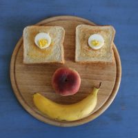 Frühstück-Gesicht mit Ei und Toas