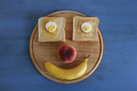 Frühstück-Gesicht mit Ei und Toas