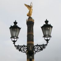 Die Berliner Siegessäule mit zwei Straßenlampen